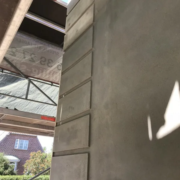 Nærbillede af nyudstøbt og pudset søjle med glat betonflade