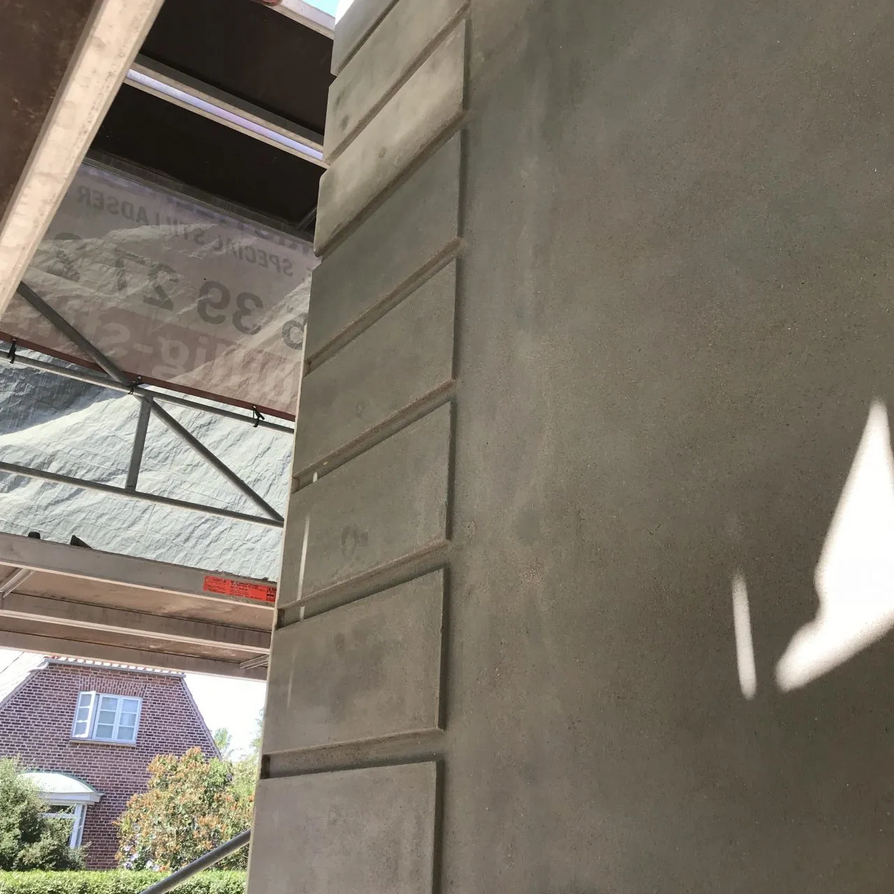 Nærbillede af nyudstøbt og pudset søjle med glat betonflade